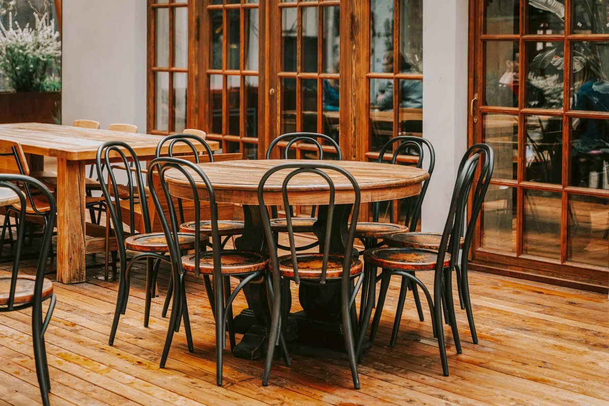 Round empty wooden table and chairs for meeting up in room, vintage style