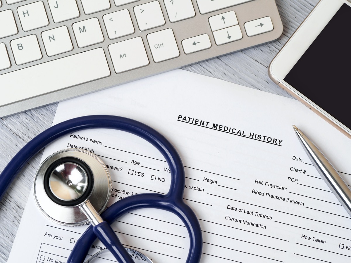 Stethoscope lying on patient medical history form. Therapist working table. Healthcare and medical concept