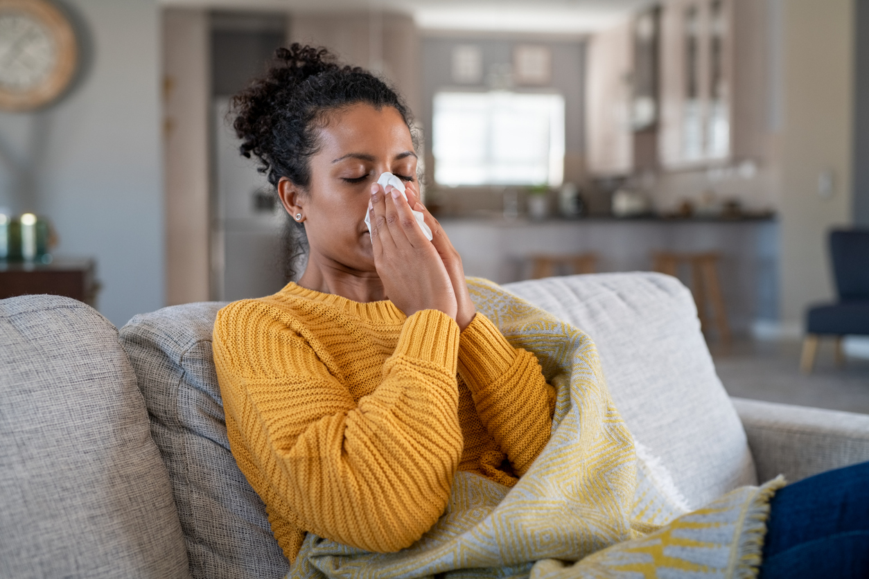 Woman with a cold blowing her nose. 