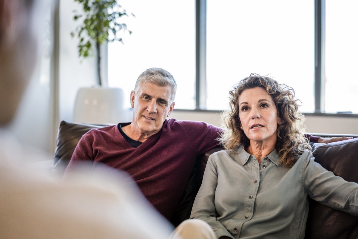 older couple talking to a man out of the screen while sitting on a couch