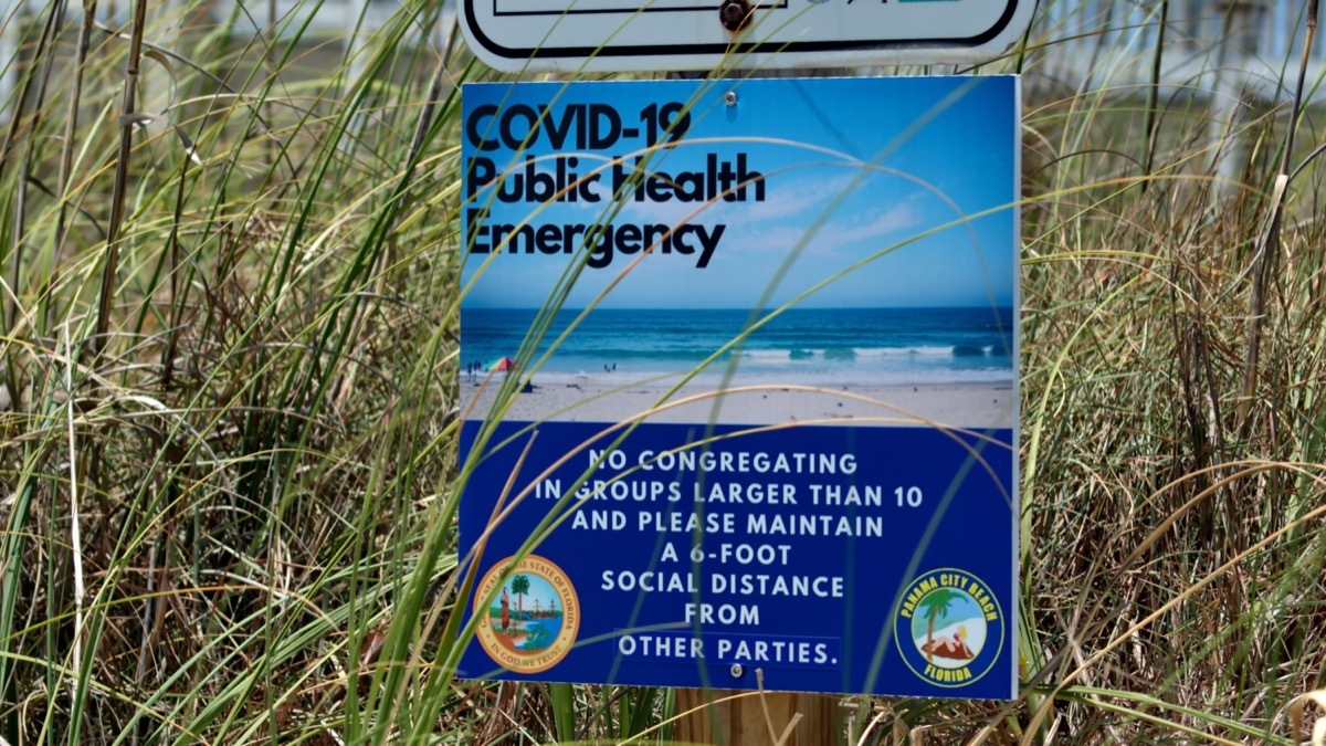 COVID-19 public health warning sign beach Florida