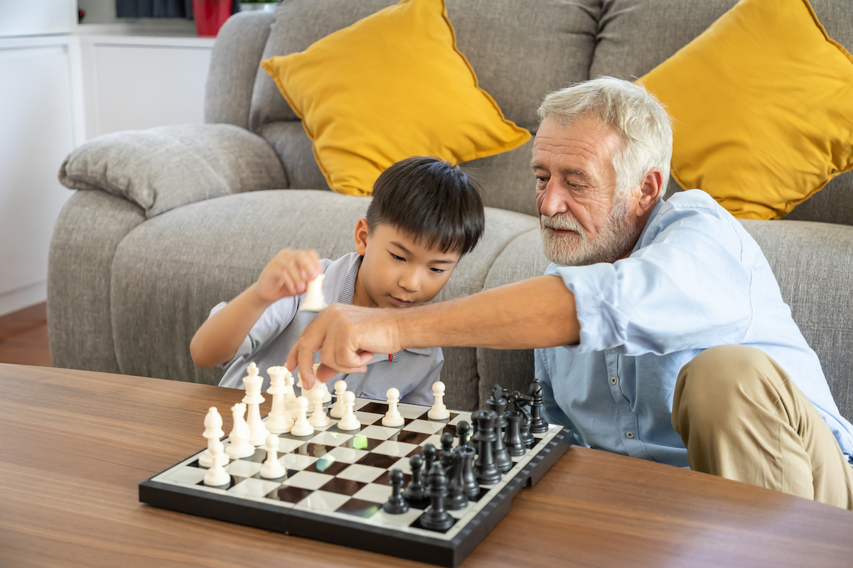 Man playing chess with his grandson