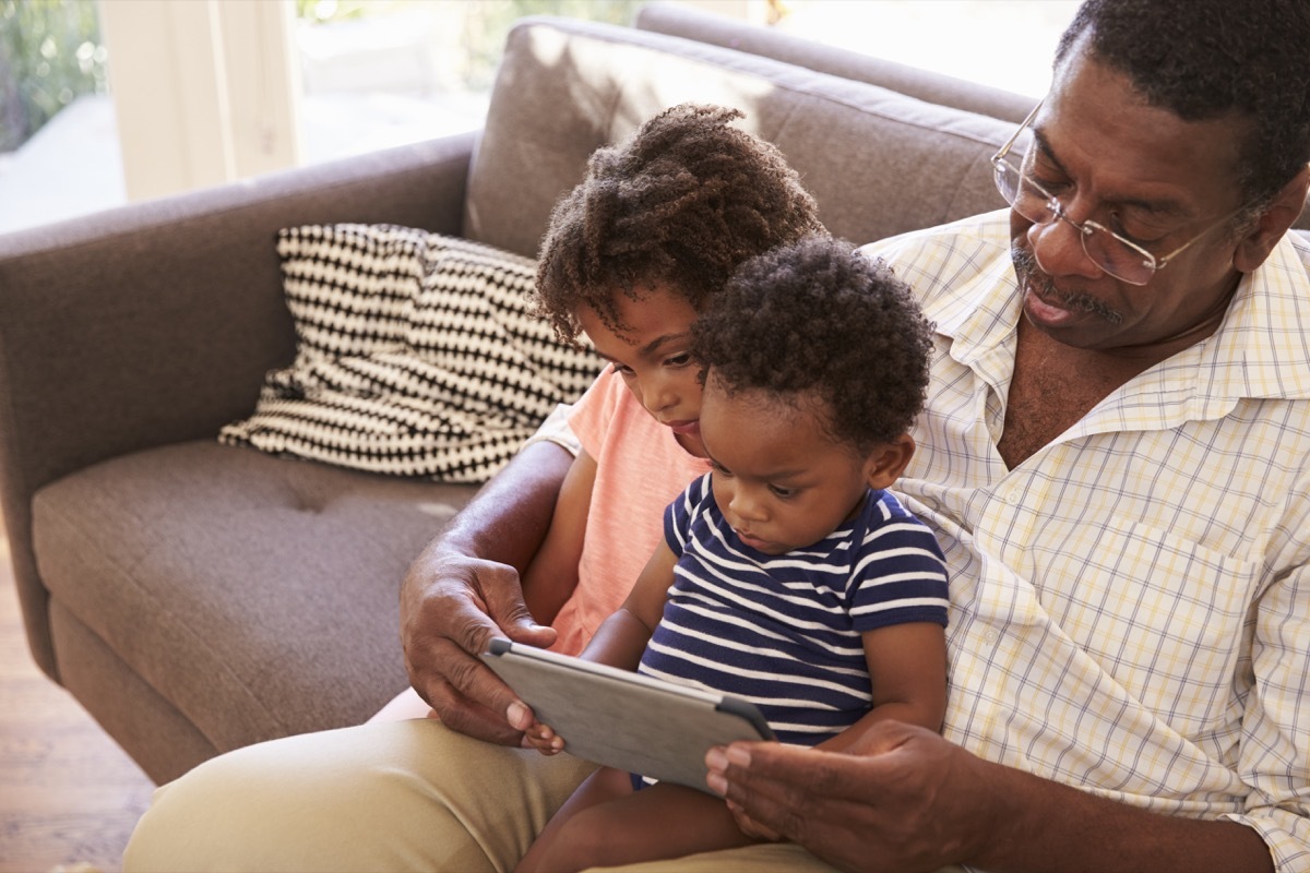 grandpa playing with grandkids on tablet