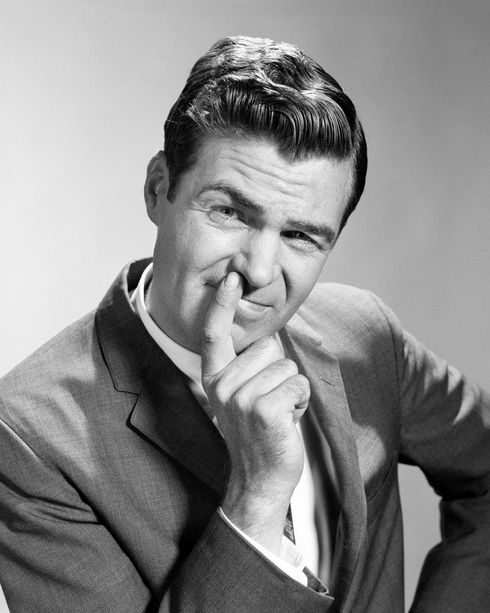 1960s man has hands on mouth, looks disgusted