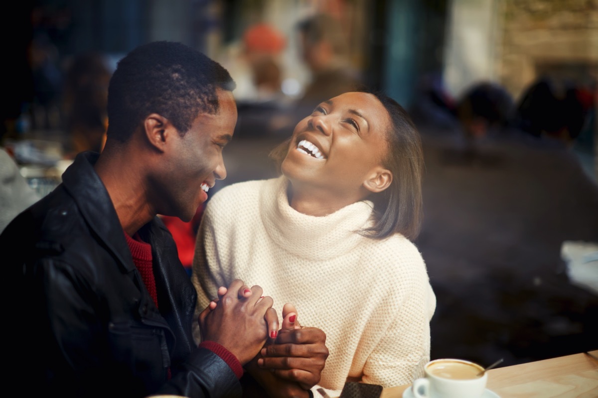 man and woman in a cafe laughing