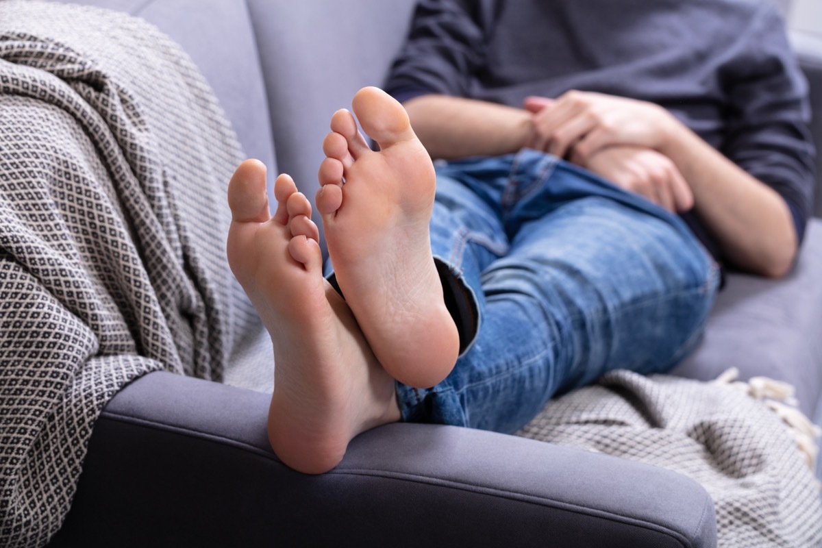 Man resting on couch with feet up