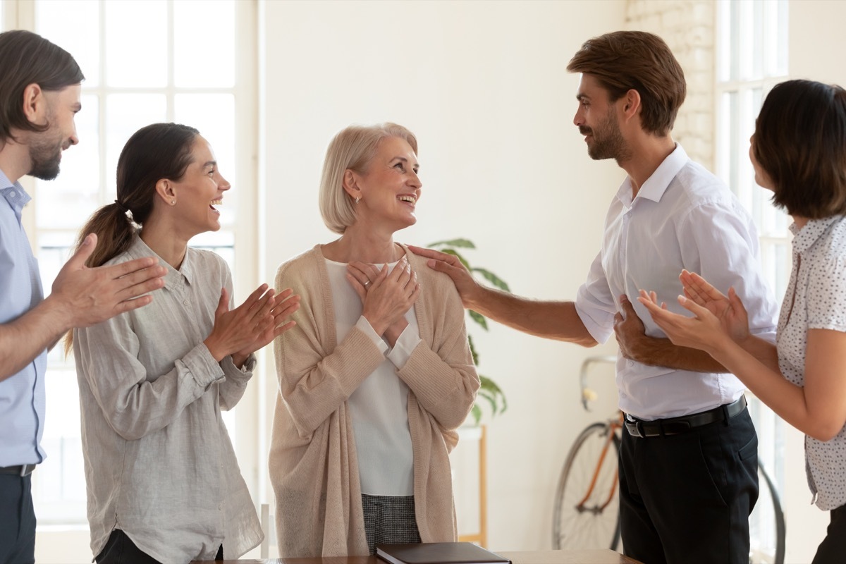 Older woman receiving compliments thankful to coworkers