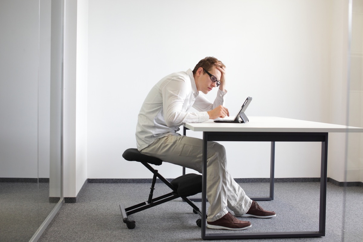 white man with bad posture slouching over his computer