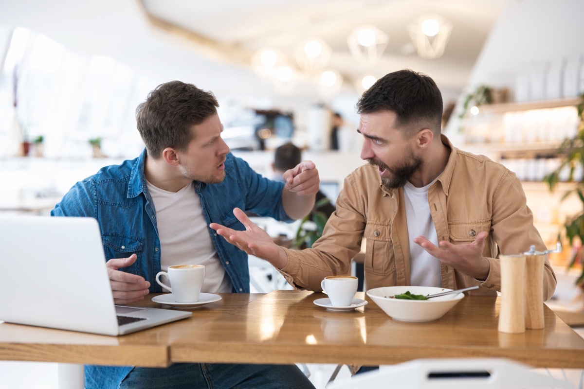 man criticizing friend at lunch