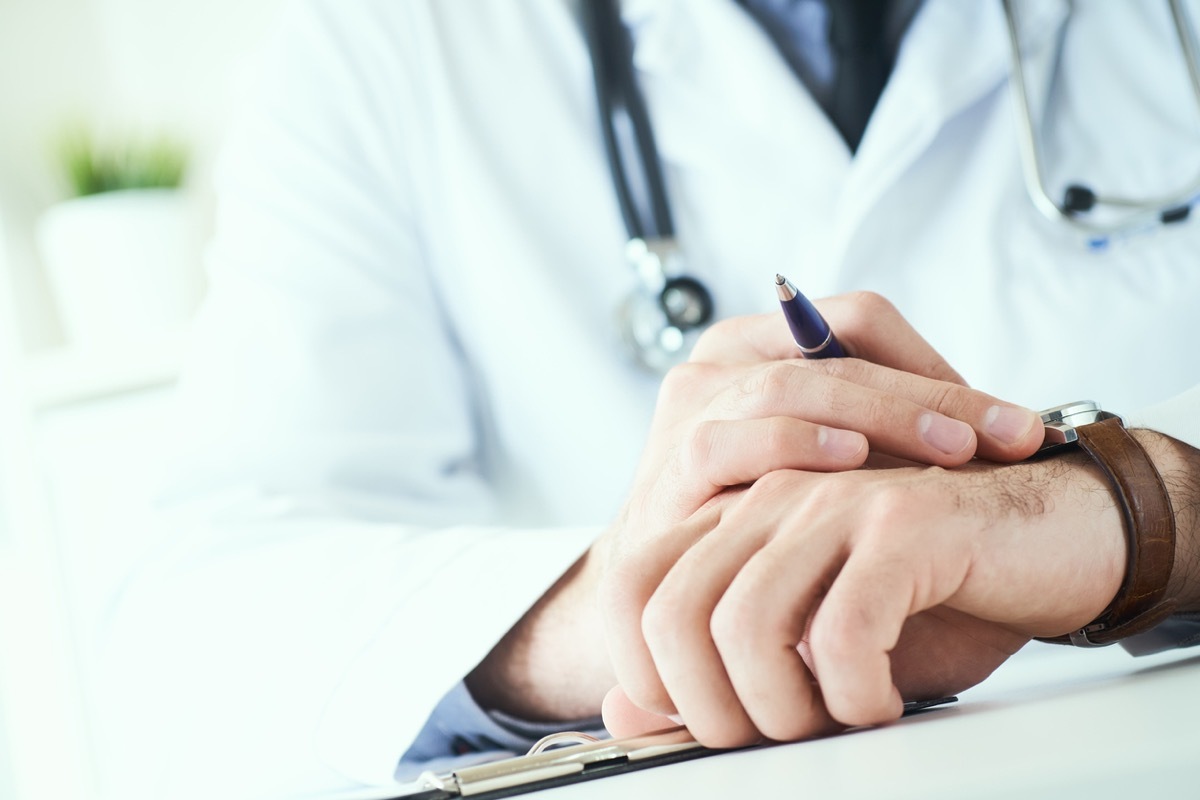 close up of white male doctor looking at his watch