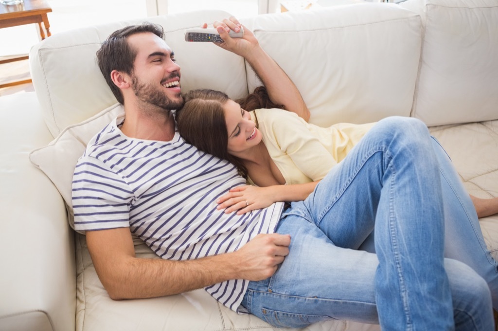 couple laughing together on couch crazy health benefits of laughter