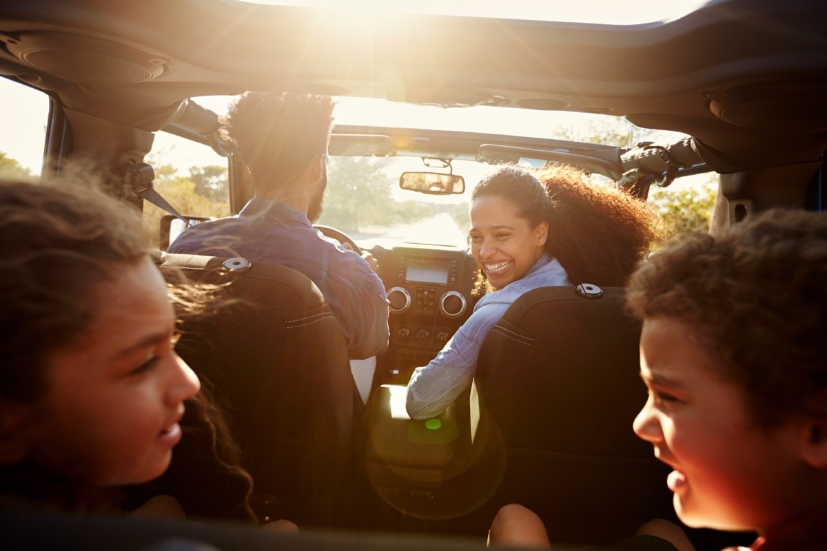 black mother and father and two young kids in car