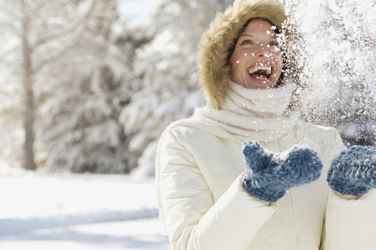 woman laughing in the snow - winter blues