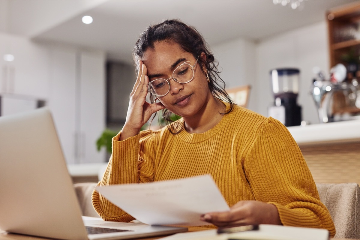 Shot of a cafe owner looking stressed while looking at paperwork