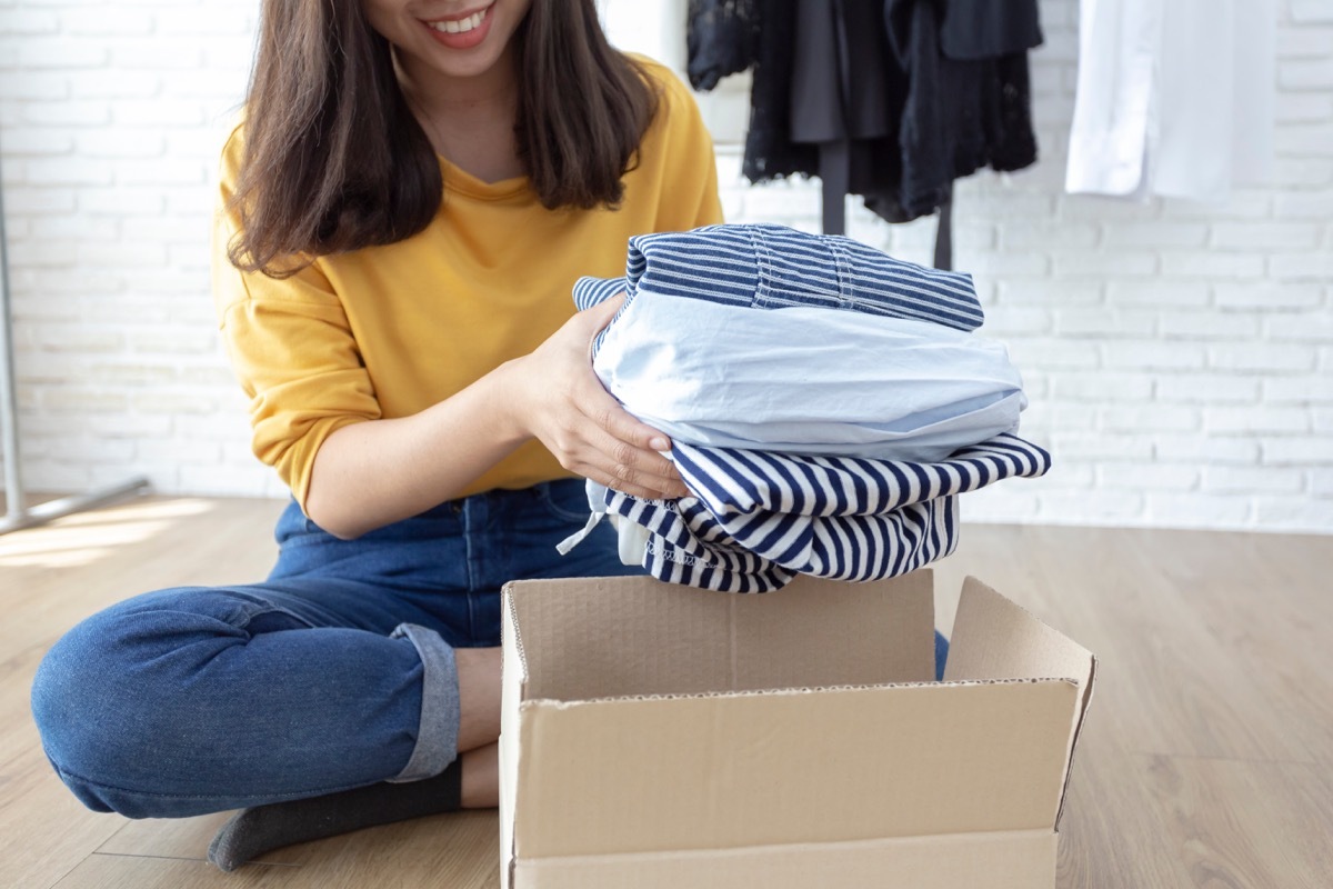 Woman putting clothes in box to donate