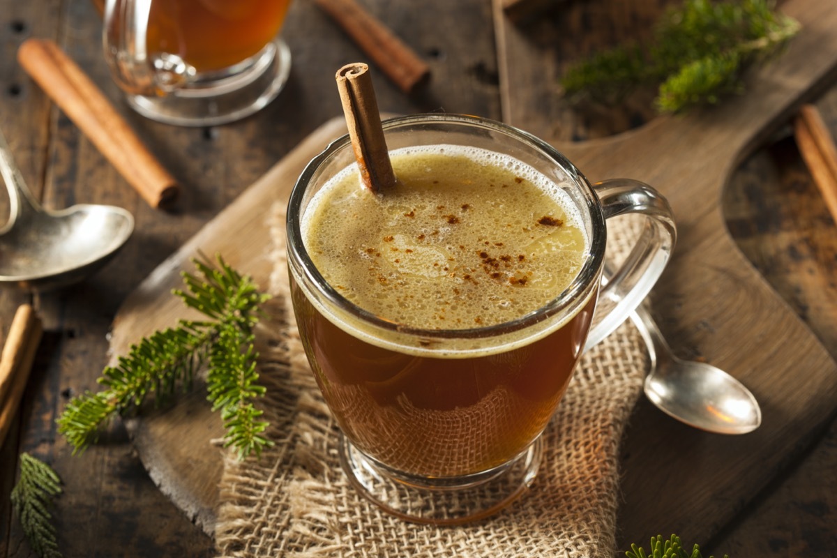 hot buttered rum in mug with cinnamon stick in clear mug