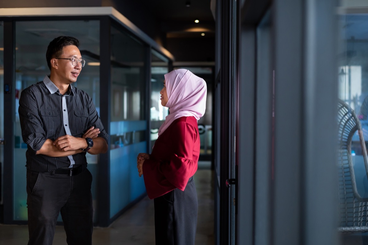 coworkers having discussion in hallway