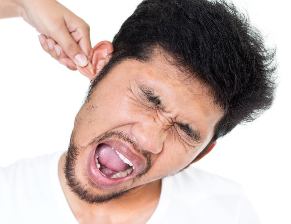 Woman's hand pulling a man's ear