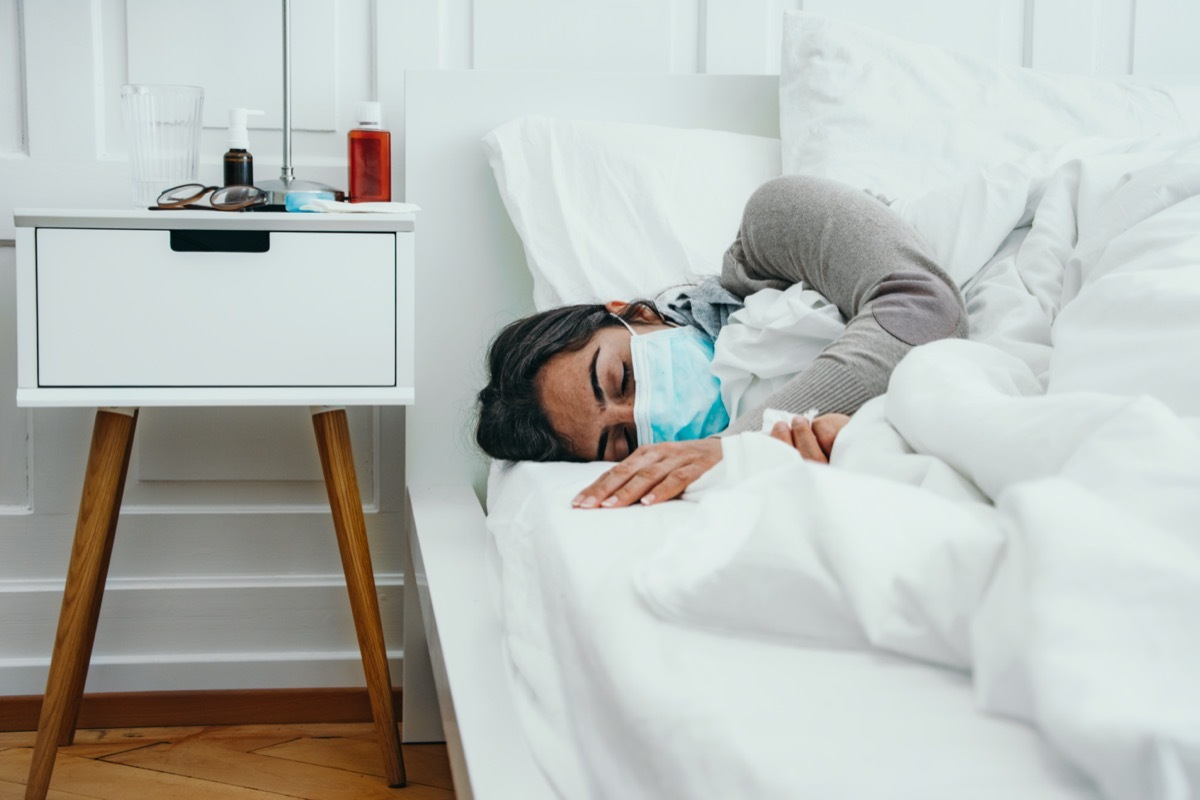 Woman sleeps in bed with a face mask on