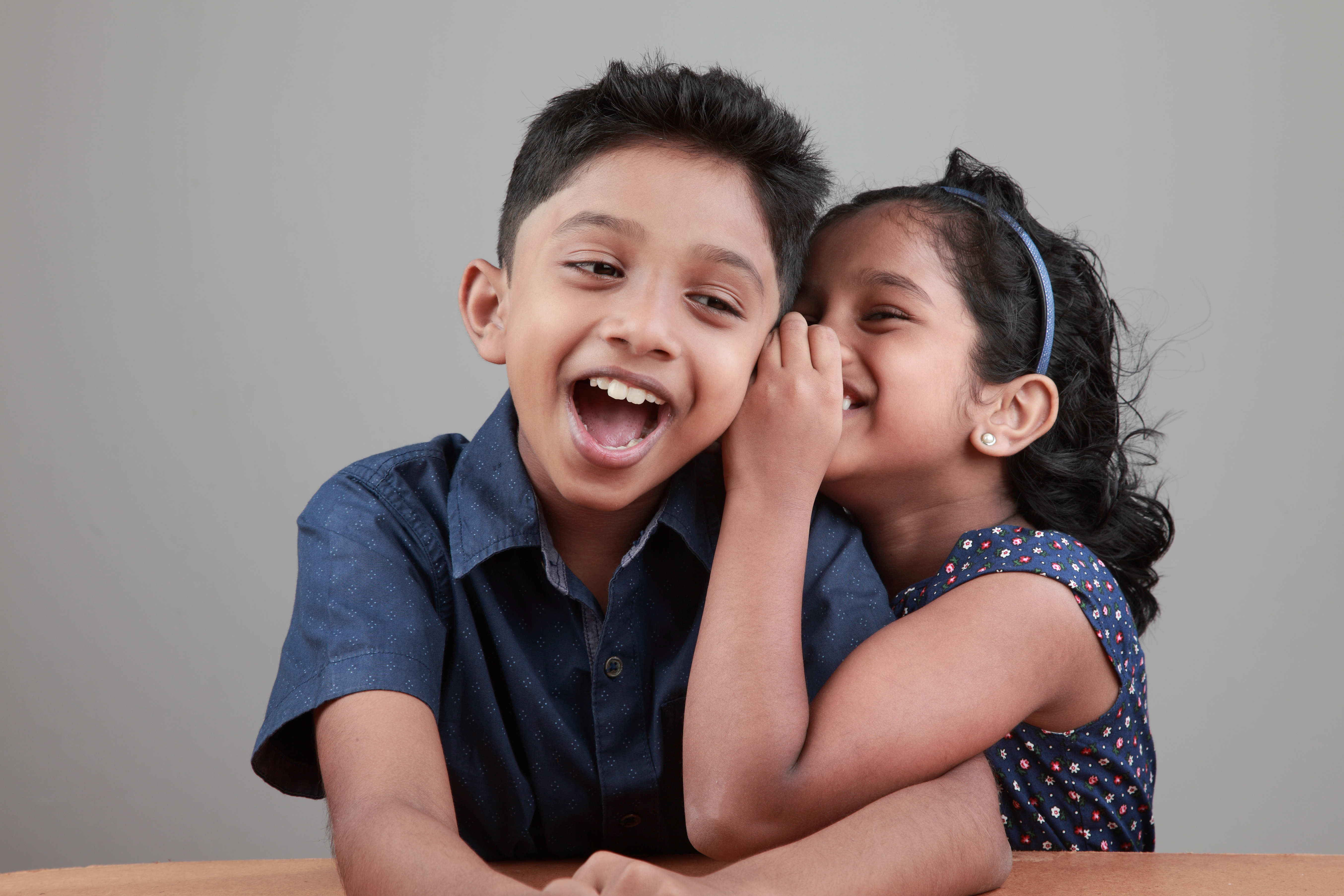 little girl sharing a knock-knock joke with her friend