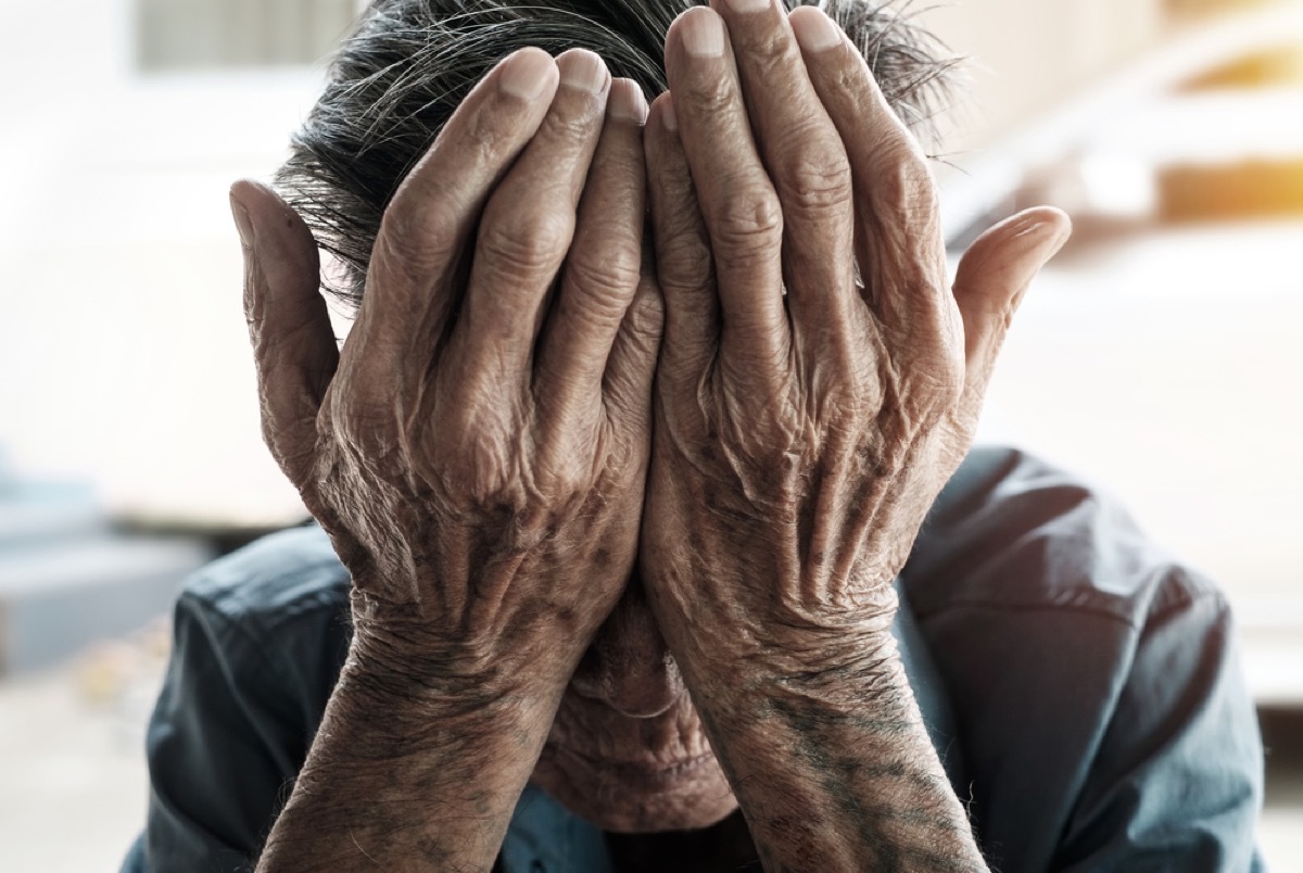 older man with face in hands