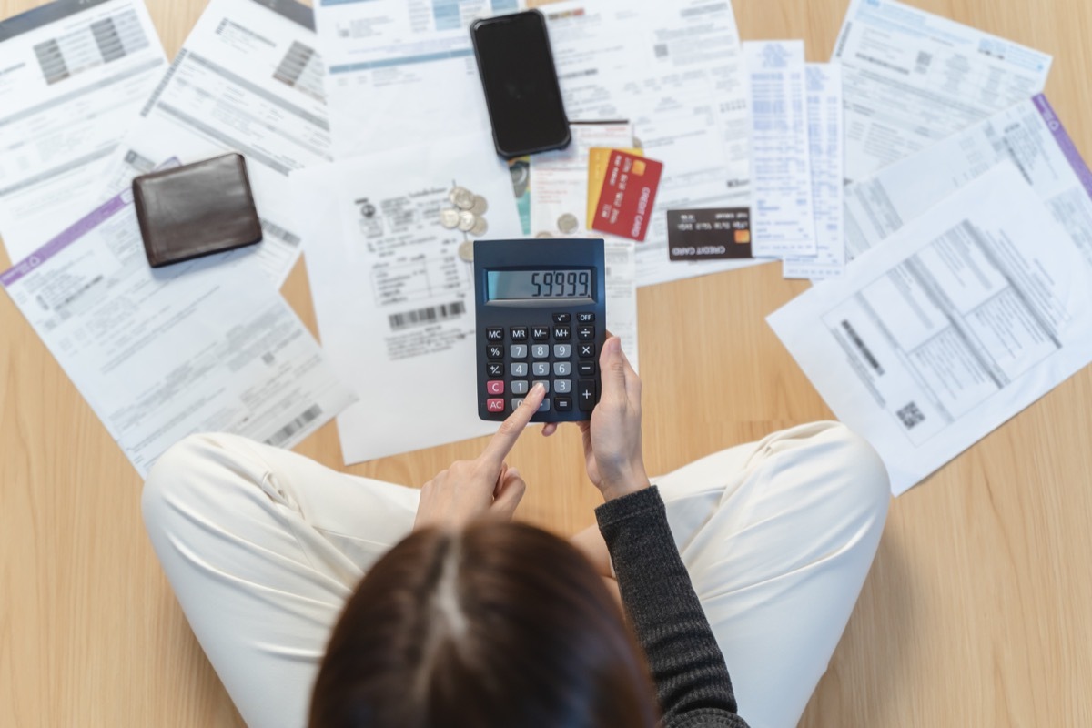 Sad woman looking at many credit cards in her hand and worried about loan debt pay late.