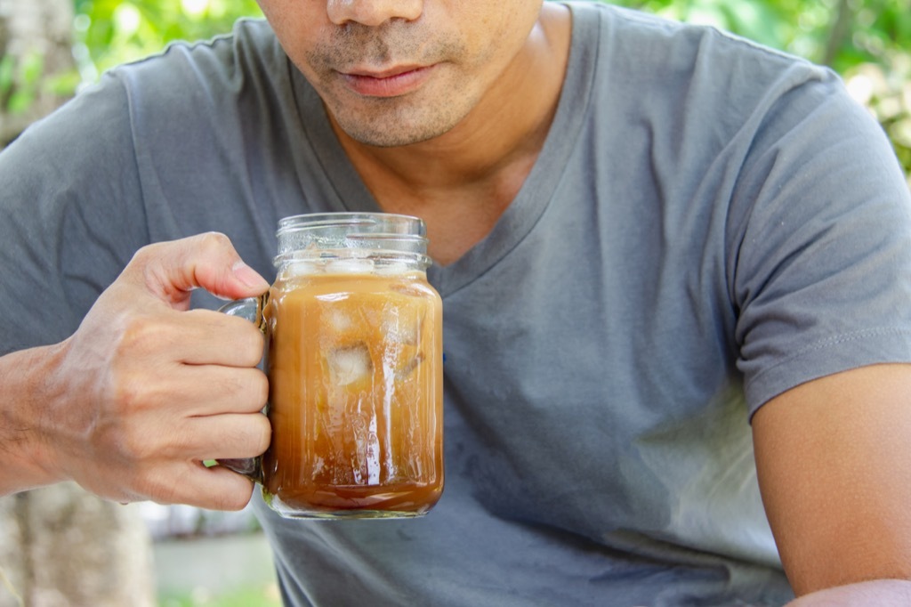 Man drinking iced coffee without a straw, best anti-aging tips