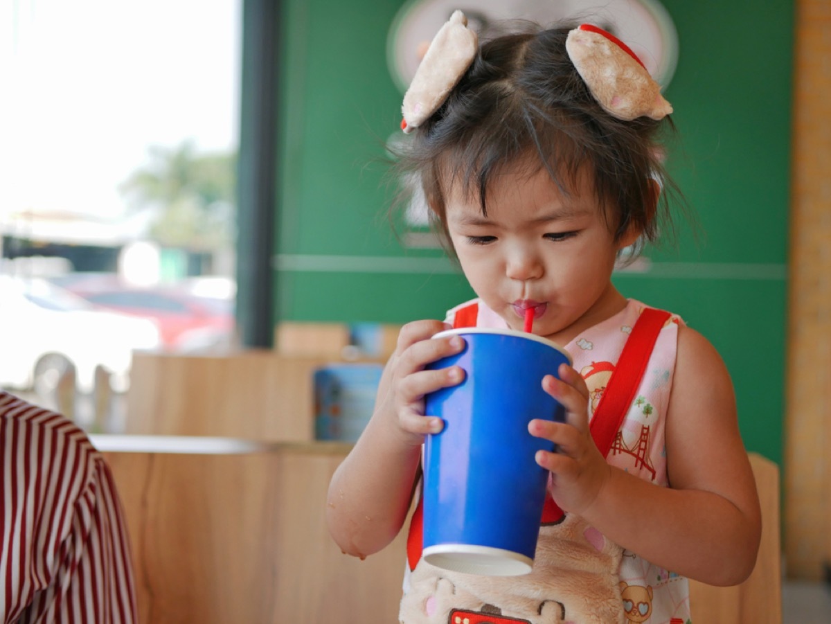 little girl drinking soda from cup with straw, bad parenting advice