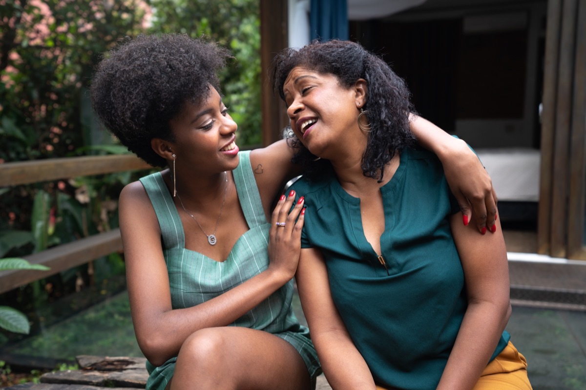 mother and adult daughter talking outside on the porch