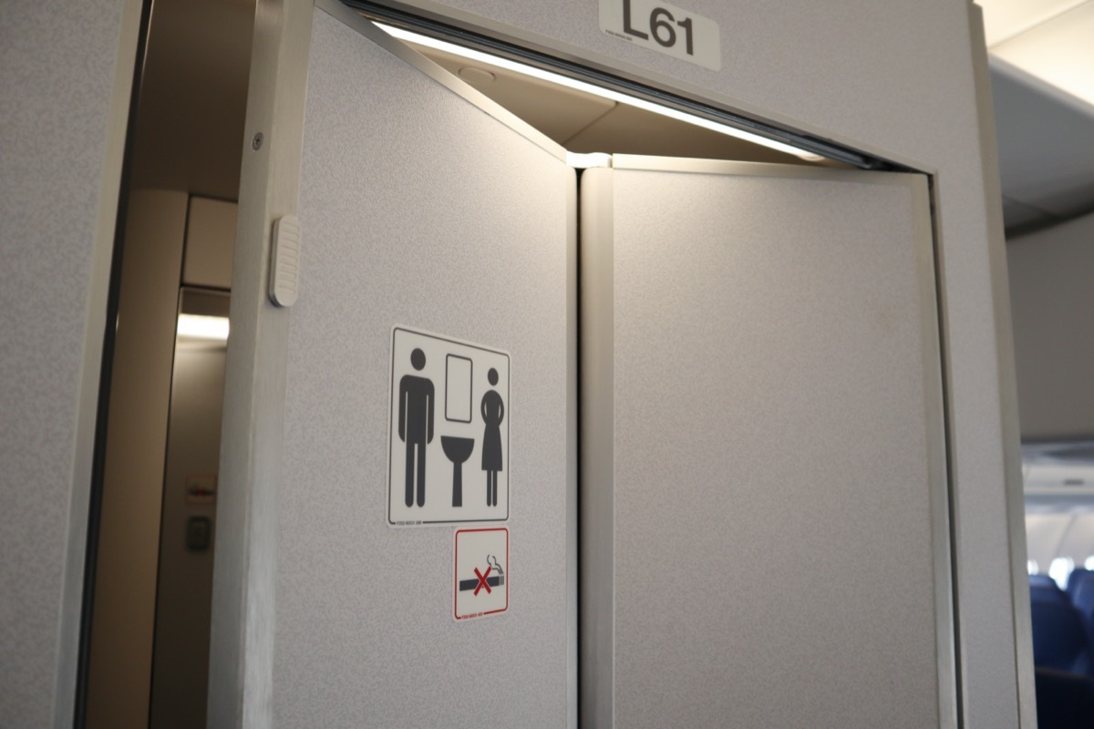 single airplane bathroom slightly open