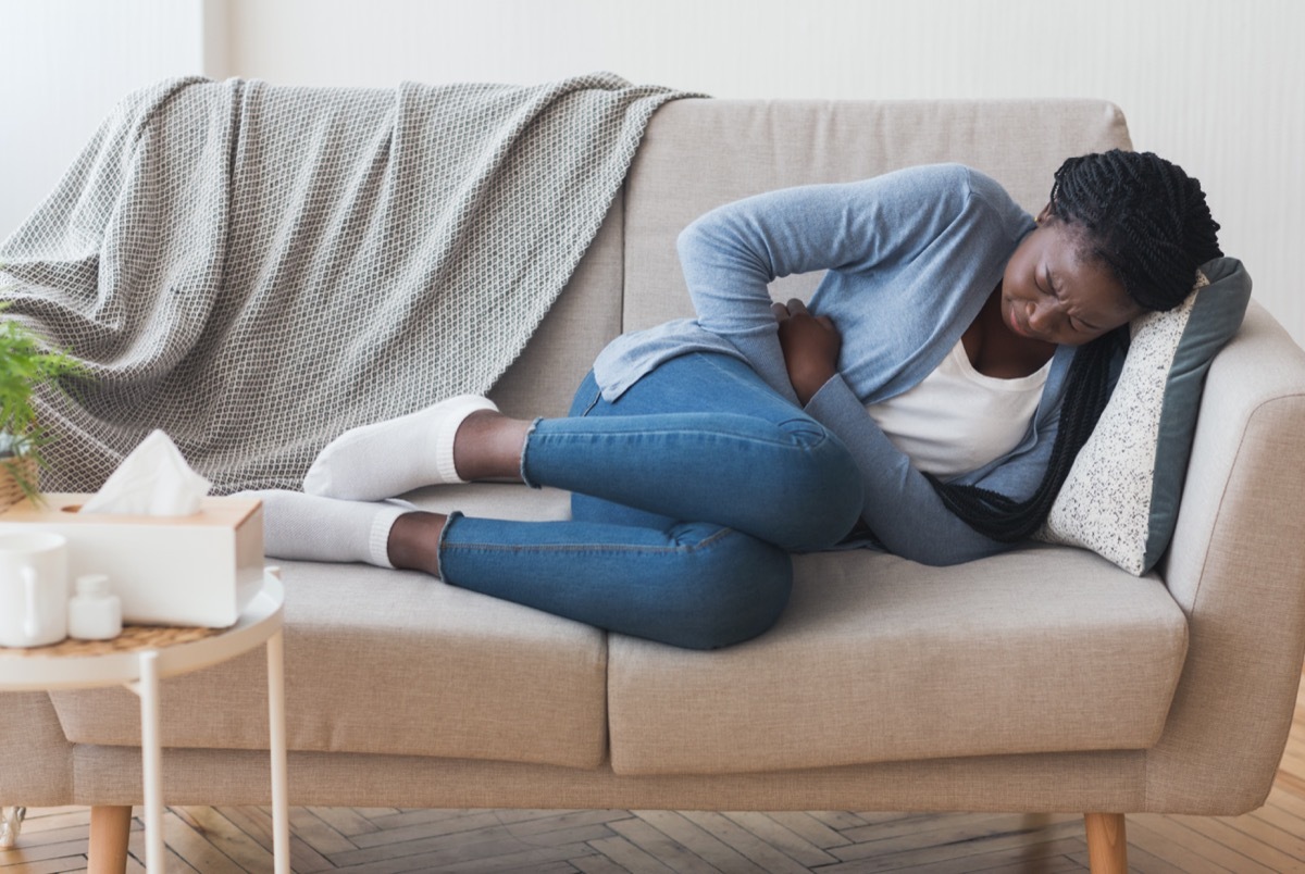 Black woman holding her stomach in pain