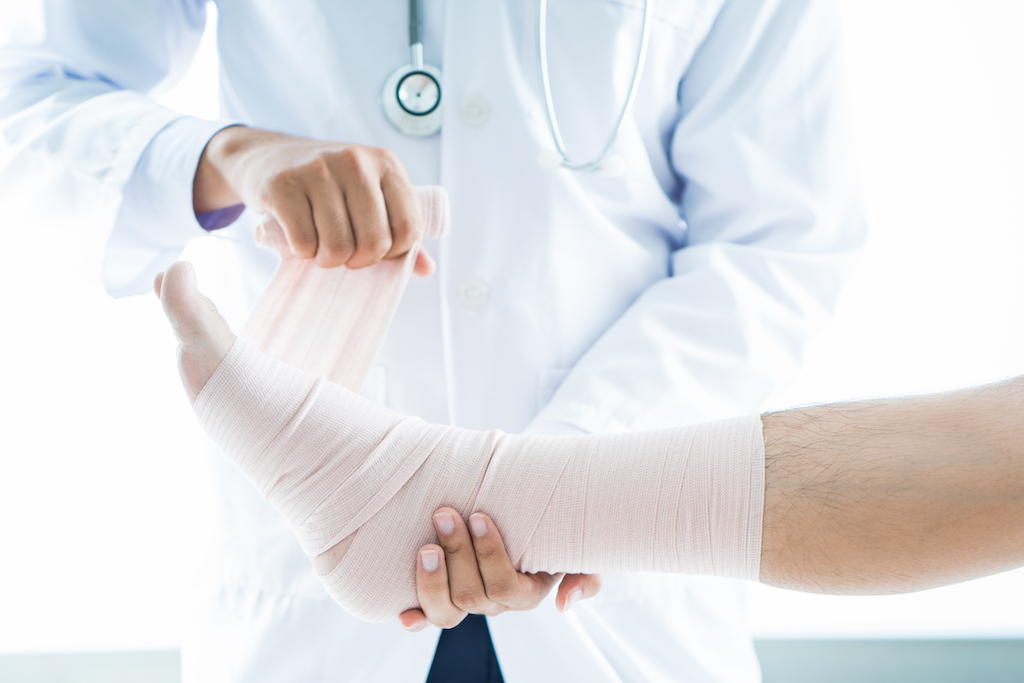 man getting his ankled wrapped by a doctor because of an ankle fracture