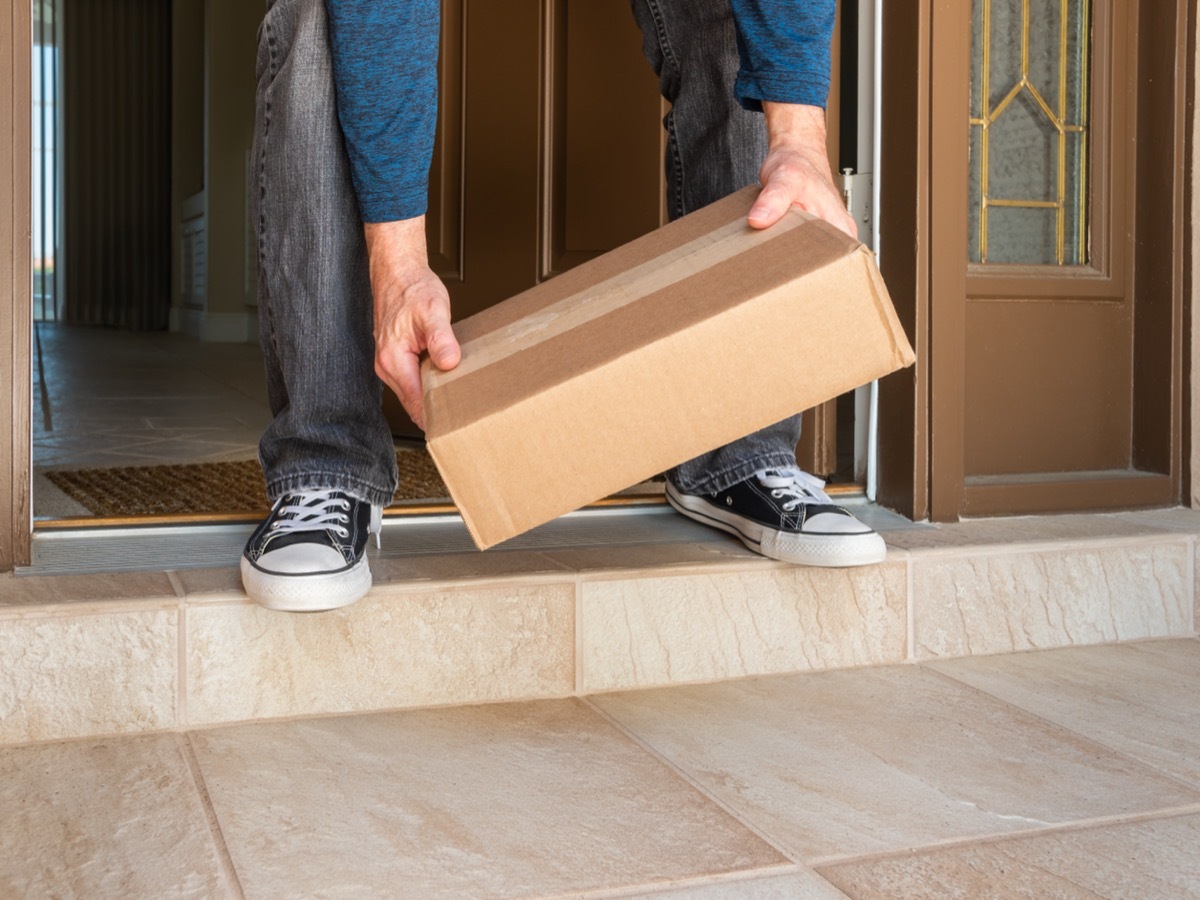 man picking up package