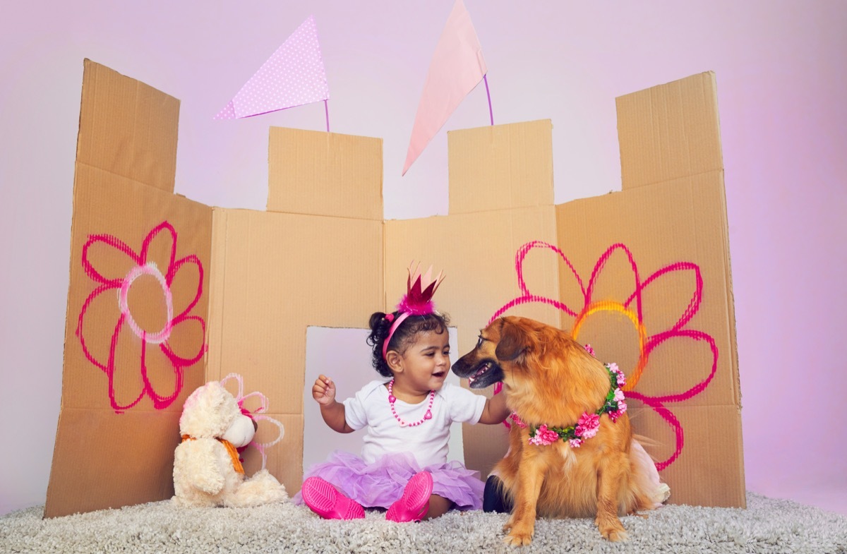 Little girl playing dress up with her dog