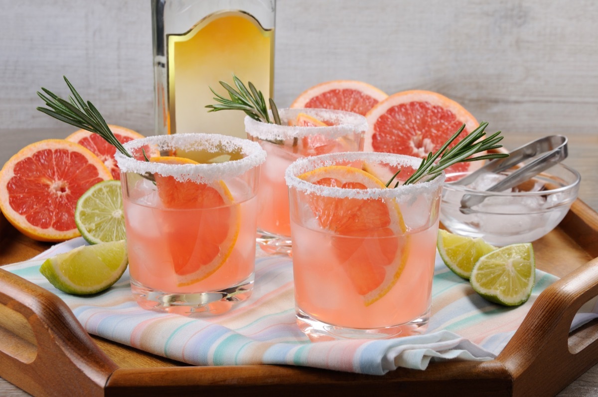 pink palomas, three glasses with grapefruit and rosemary garnishes