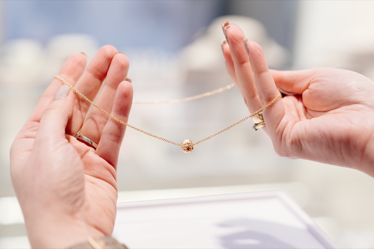 Hands Holding a Gold Necklace