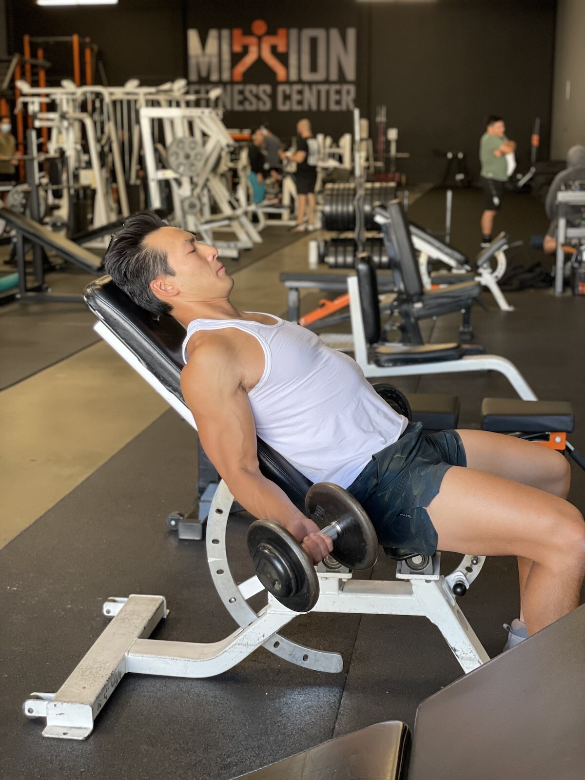 tim liu doing a dumbbell curl