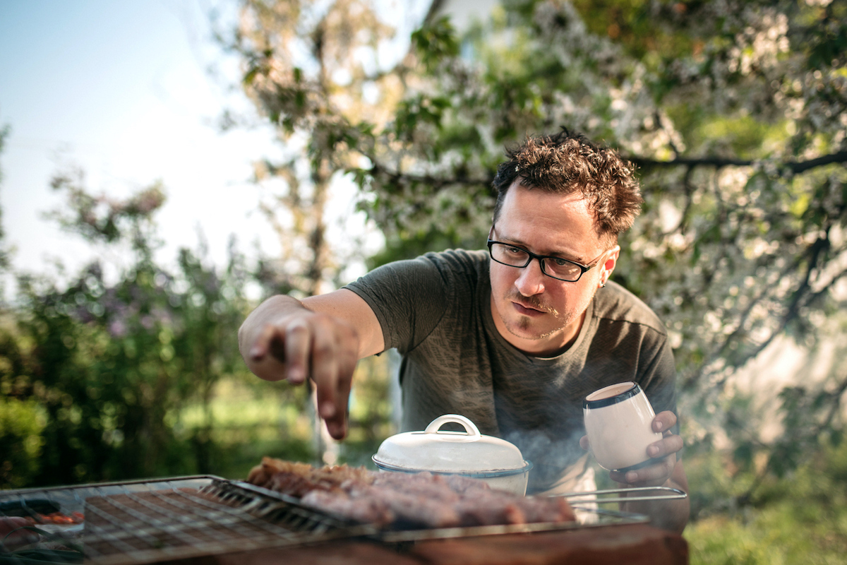 Man cooking for family having barbecue party in summer