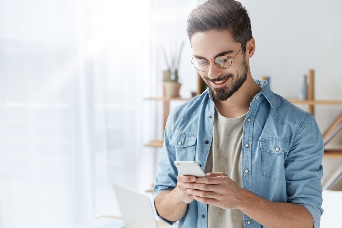 Man smiling looking at phone