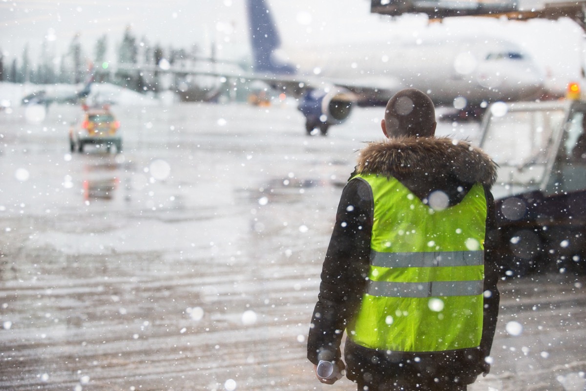 airport ground worker in the middle of a blizzard