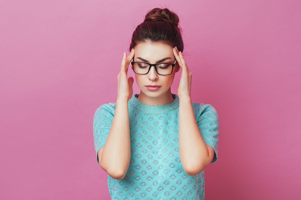 woman with hands on her head thinking or with headache every day words