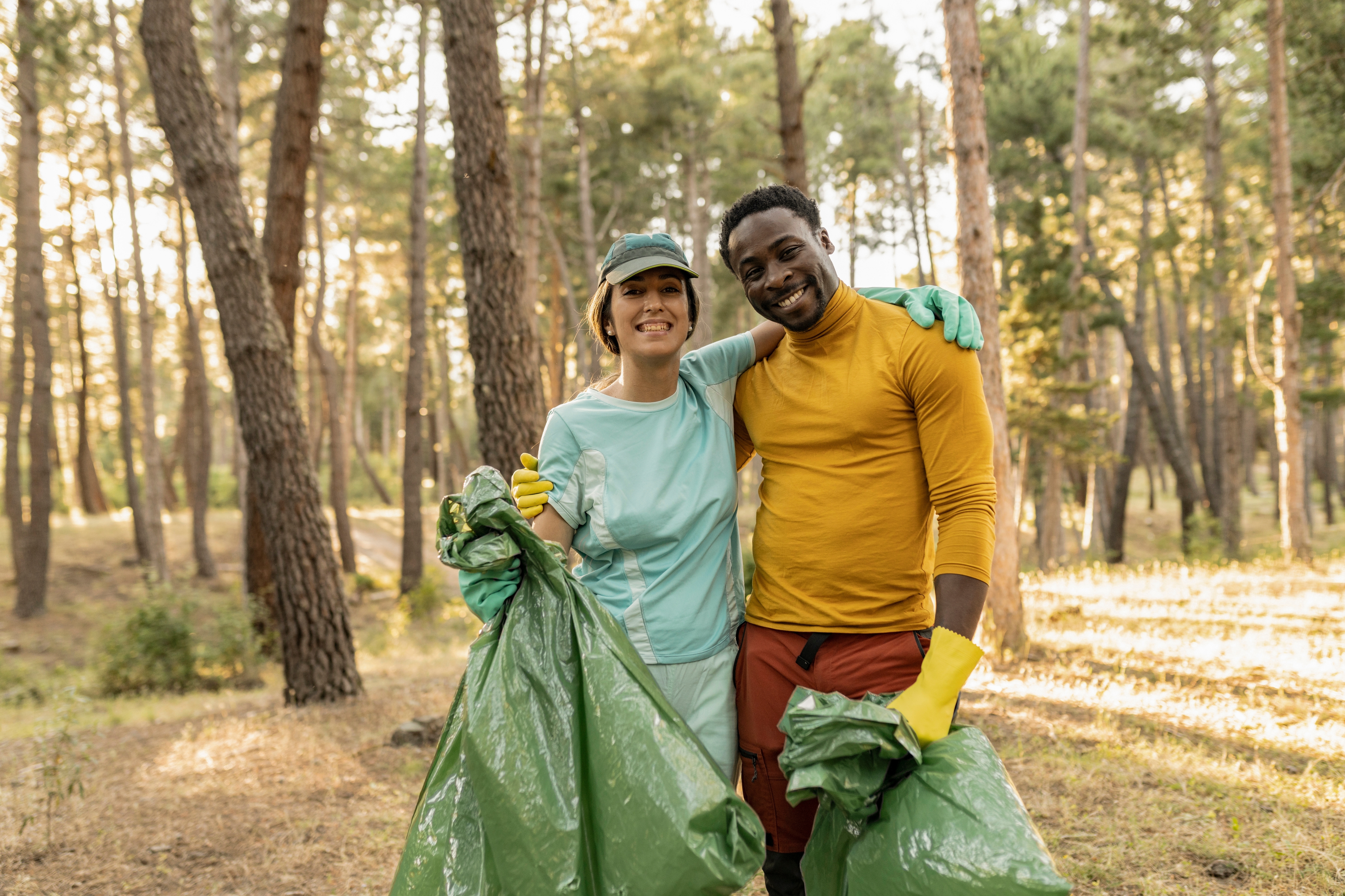 couple volunteering picking up trash in the woods