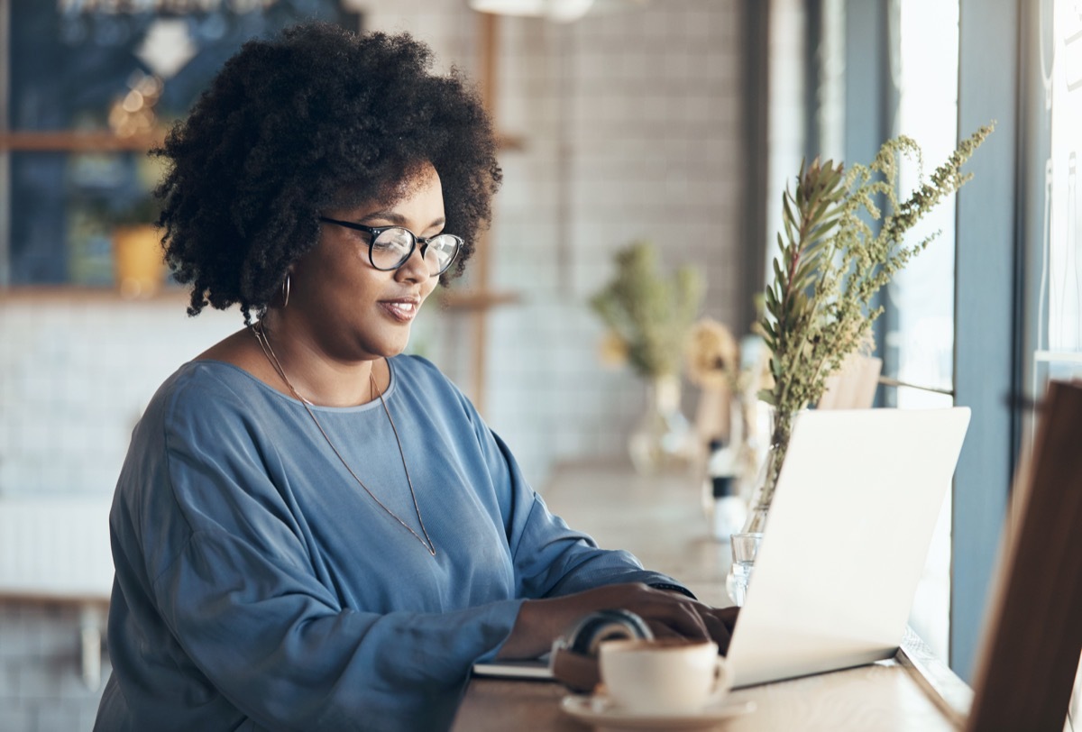 Shot of an attractive young businesswoman sitting and working on her laptop in a coffee shop during the day