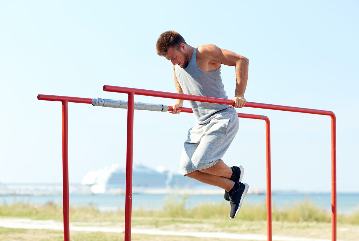 man doing dips outside