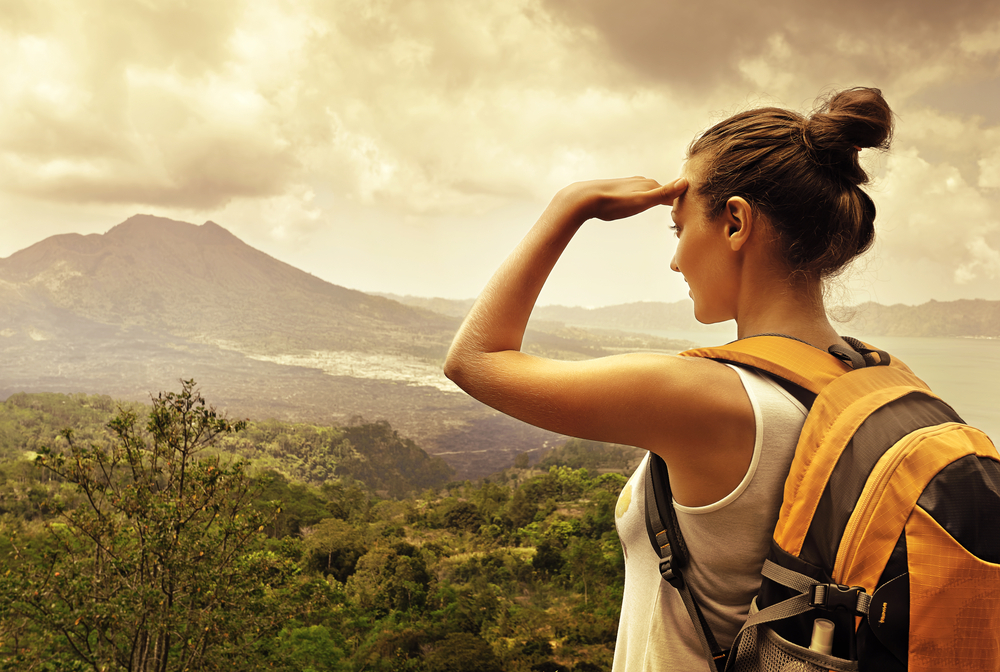 solo female traveler surveys her lush surroundings