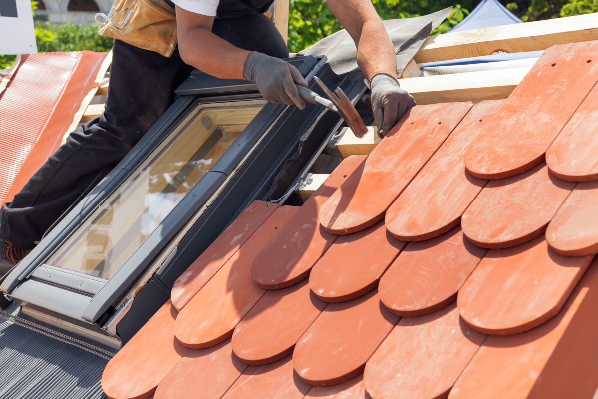 Man laying new tile on the roof