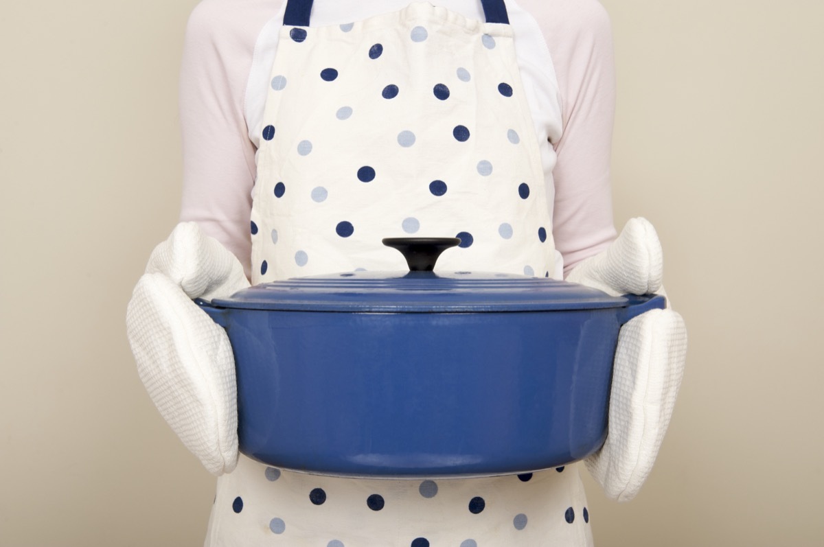 woman holding a blue casserole dish