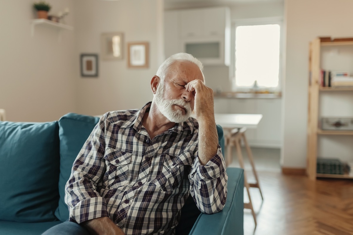 a man sitting in his home, feeling tired