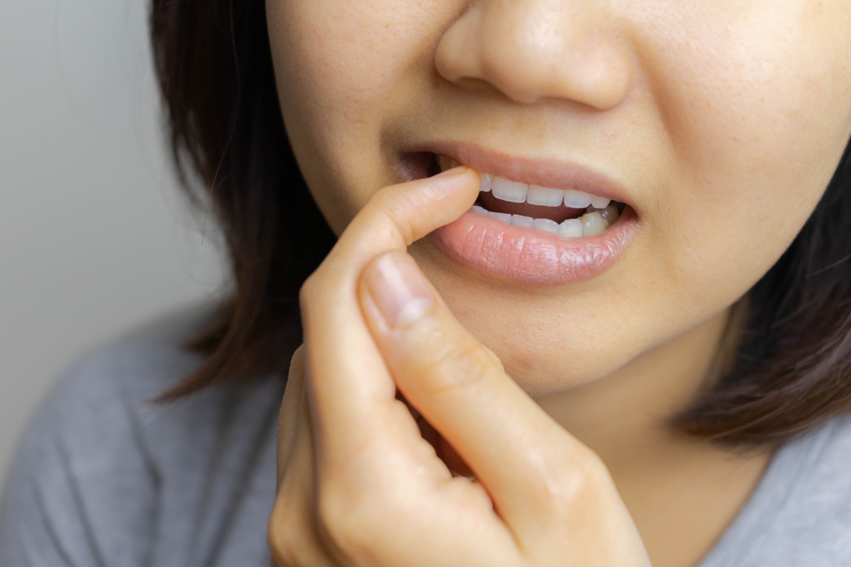 young asian woman picking teeth