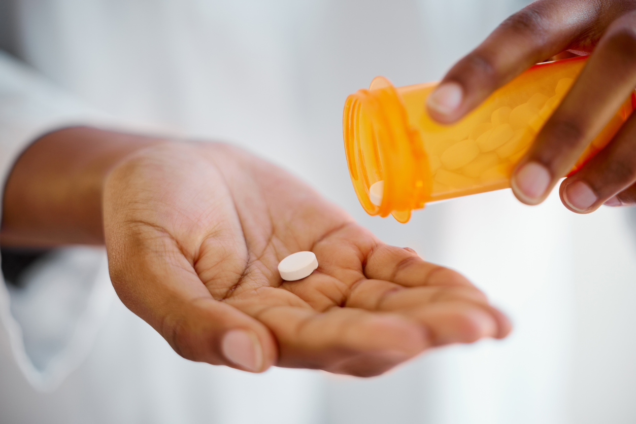 Pill in the palm of a person's hand. 